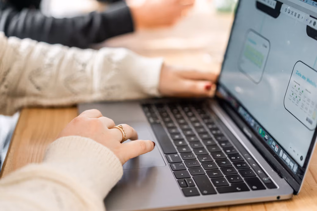 Nahaufnahme eines Laptops, auf dem eine Mitarbeiterin an einem digitalen Projekt arbeitet.