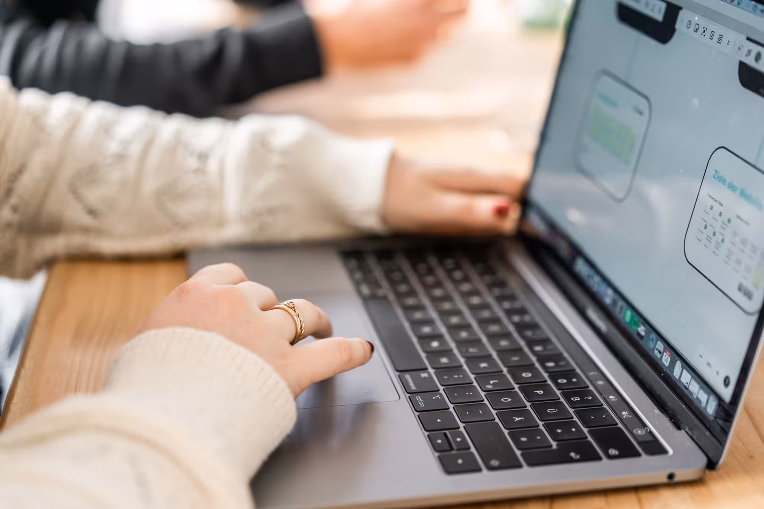 Nahaufnahme eines Laptops, auf dem eine Mitarbeiterin an einem digitalen Projekt arbeitet.